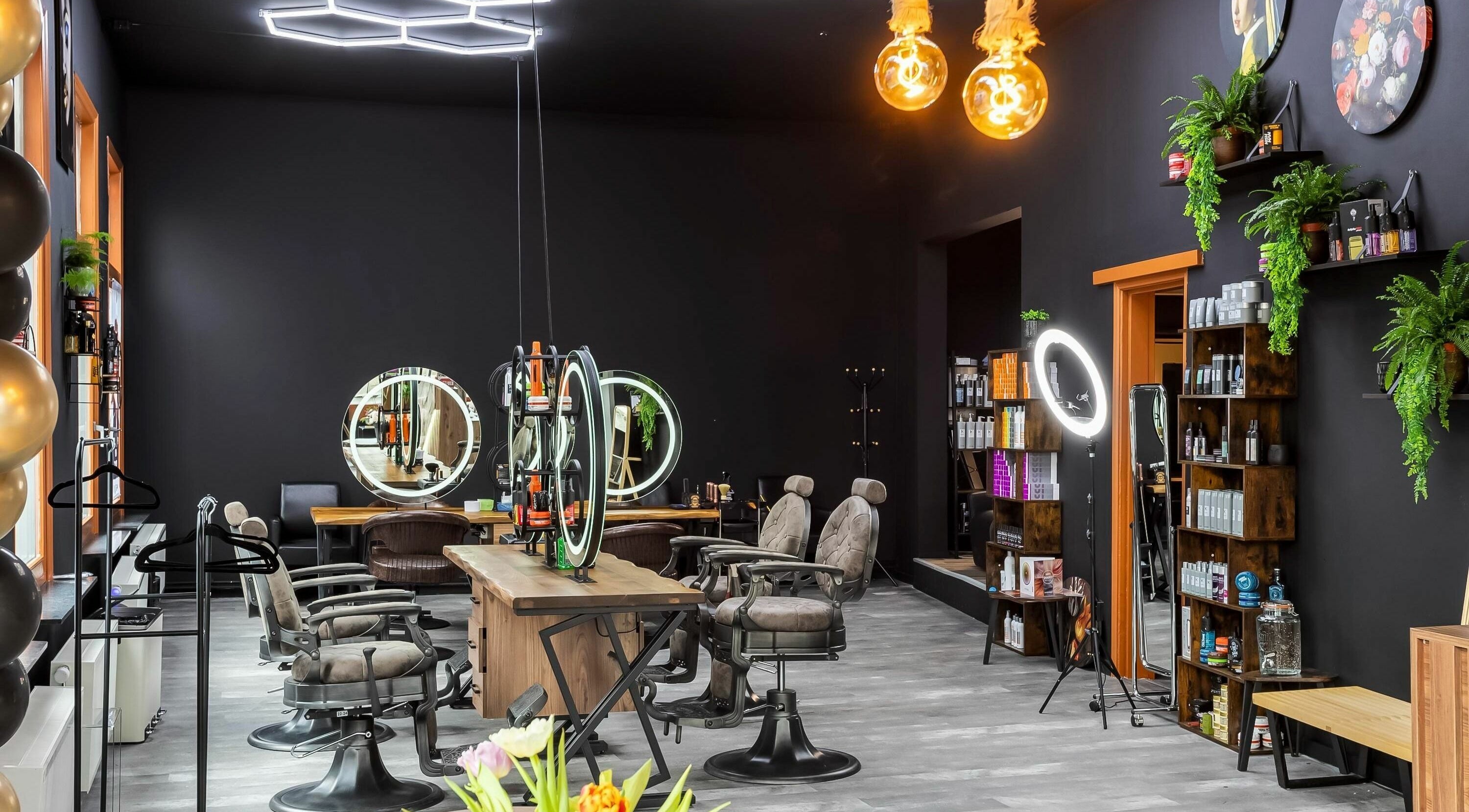 Modern interior of Empire Barbershop Amsterdam, showcasing stylish black decor and elegant chairs. Amsterdam, NL.