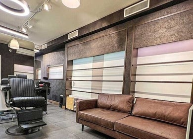 Stylish interior of Prime Barbershop Amsterdam, featuring modern barber chair and brown couch in Amsterdam, Noord-Holland, NL.