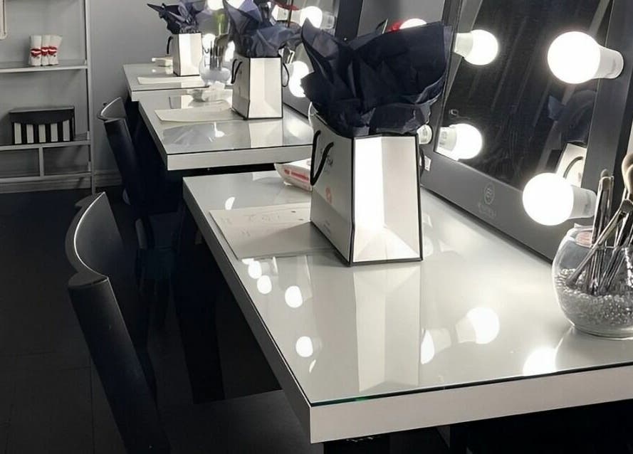 Elegant makeup stations at Selfish Beauty Lounge in Vaughan, Ontario, CA, featuring illuminated mirrors and tools.