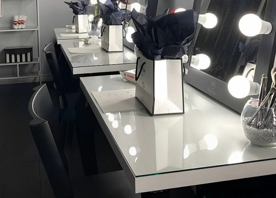 Elegant makeup stations at Selfish Beauty Lounge in Vaughan, Ontario, CA, featuring illuminated mirrors and tools.