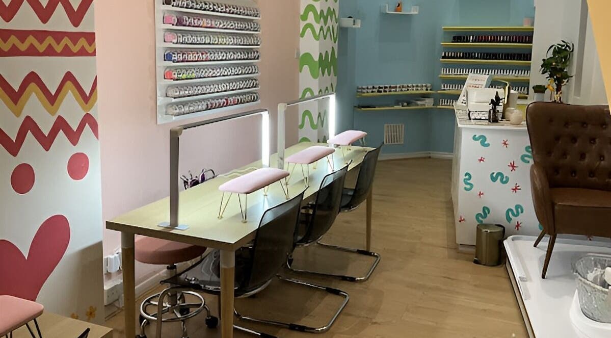 Modern, vibrant interior of The Nail Garden Shoreditch, London, England, GB with nail polish display and seating.