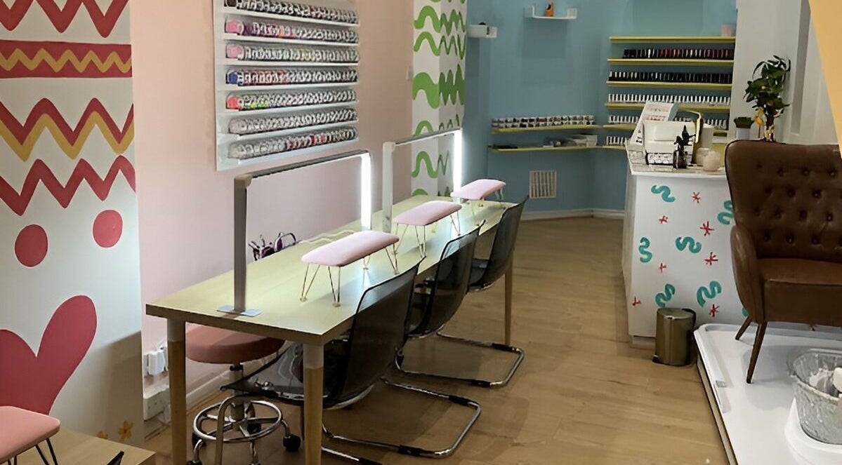 Modern, vibrant interior of The Nail Garden Shoreditch, London, England, GB with nail polish display and seating.