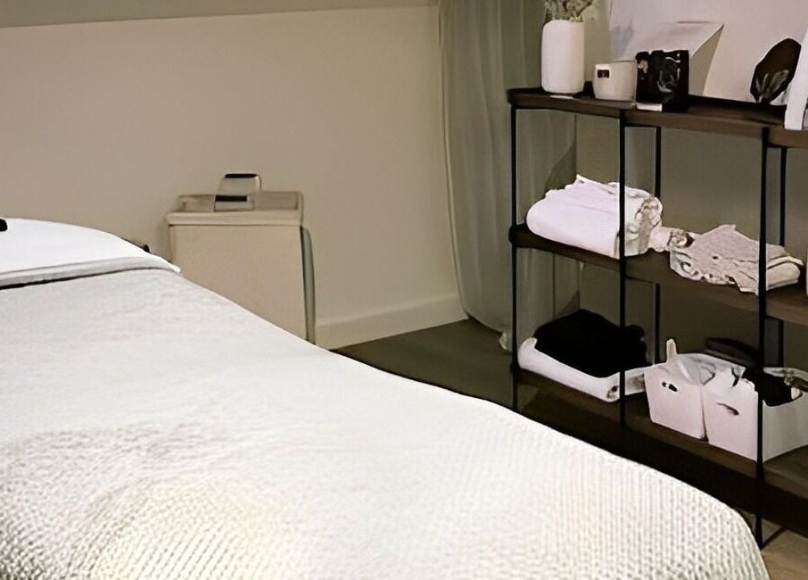 Salle de soin à Dermasens, Biguglia, Corse, FR avec lit de massage et étagères élégantes.