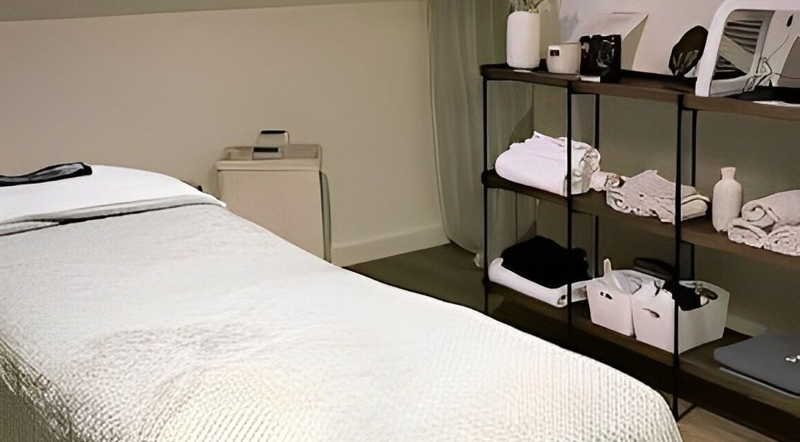 Salle de soin à Dermasens, Biguglia, Corse, FR avec lit de massage et étagères élégantes.