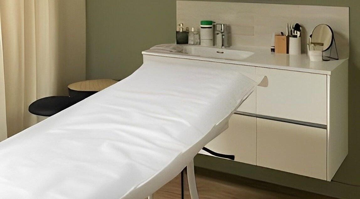 Salle de soins paisible chez Dermasens, Biguglia, Corse, FR, avec une table de massage et un lavabo moderne.