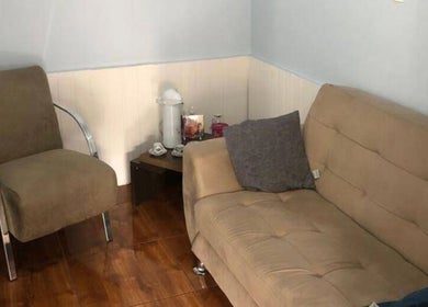 Sala de espera acolhedora em Lirios Depilação, São Paulo, São Paulo, BR, com sofá e cadeira confortáveis.