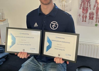 Certified therapist at Ryan Farr Sports Massage Therapy in Moira, Northern Ireland showcasing completion certificates.