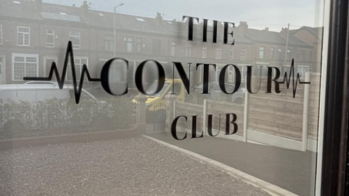 Window with The Contour Club Mcr logo in Bolton, England, GB.