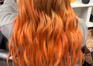 Bright, wavy orange hair styled at ALS Hair, Clonmel, County Tipperary, IE. Perfect blend of bold hues.