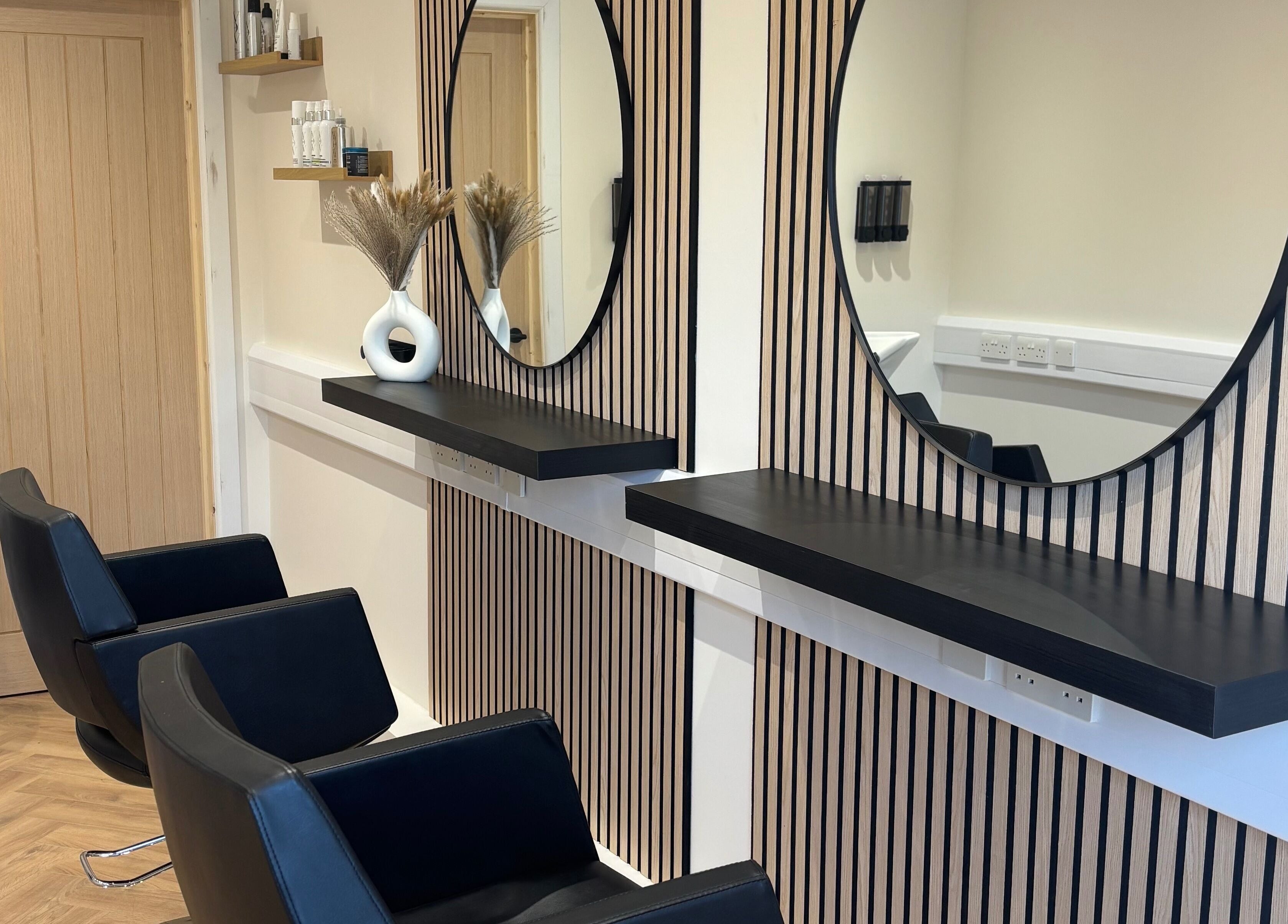 Modern salon chairs and mirrors at Francesca’s Hair Hideaway, West end, England, GB, offering chic hair services.