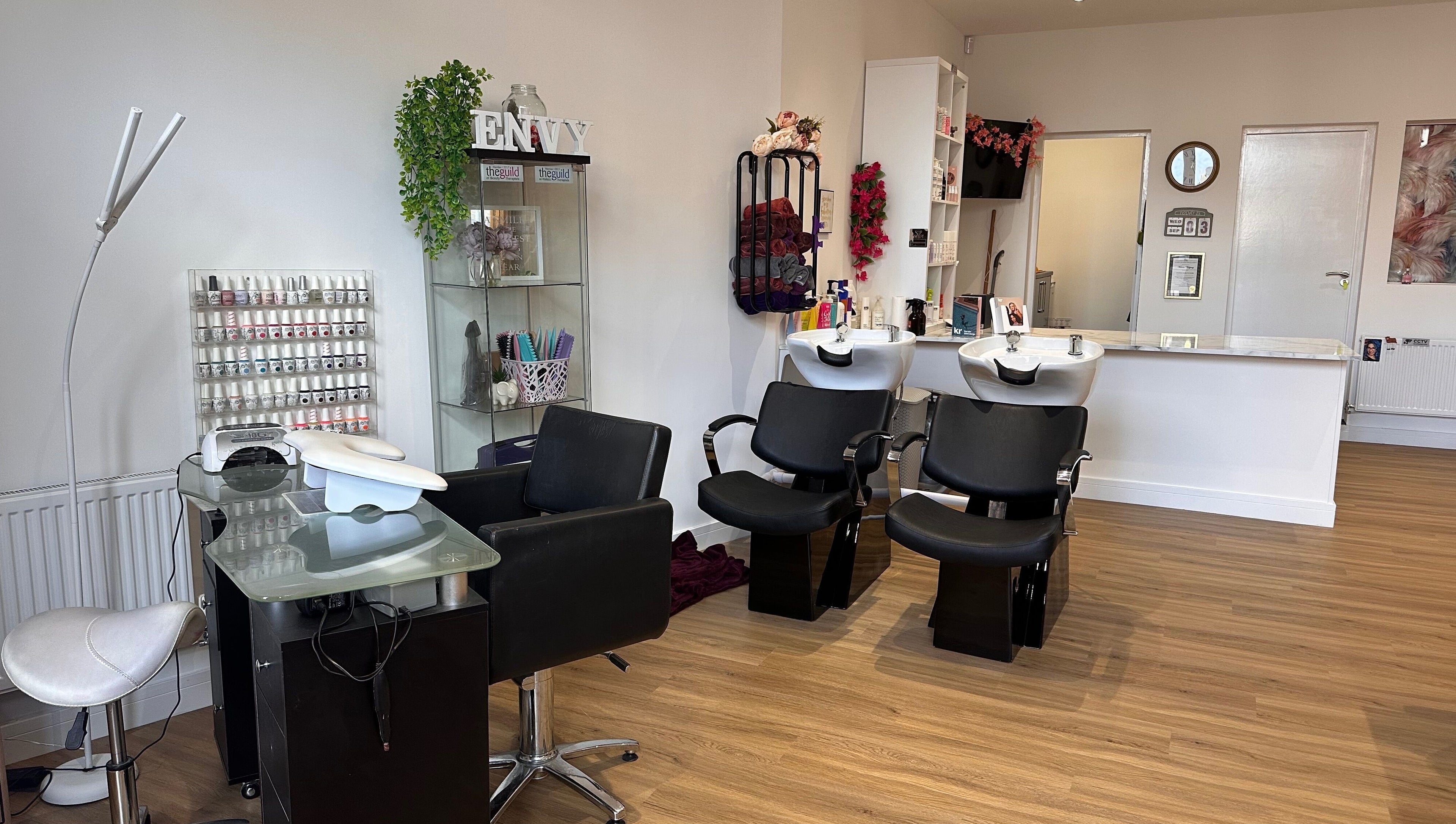Modern interior of Envy Salon in Redcar, TS10 1AD, England, showcasing stylish black chairs and beauty stations.