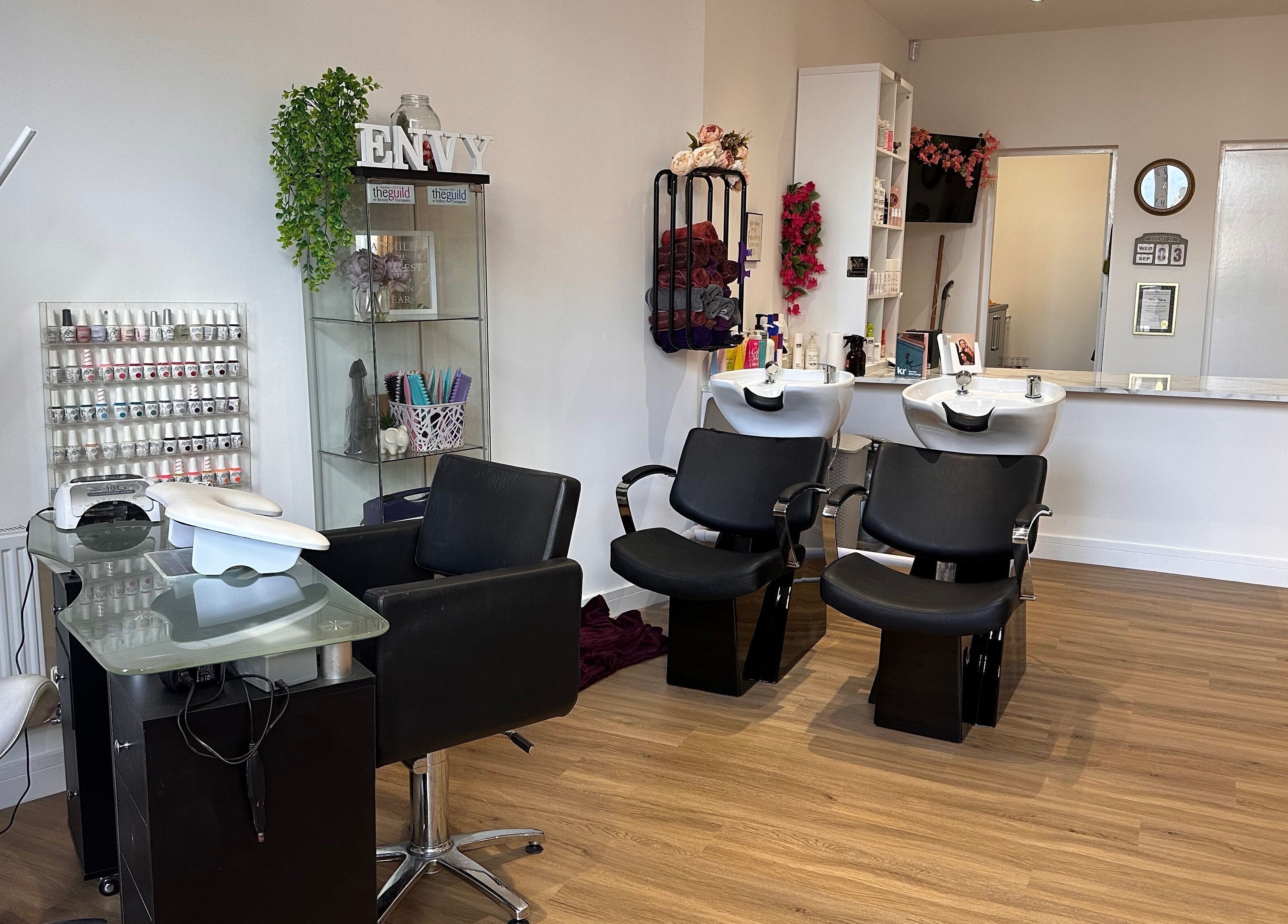 Modern interior of Envy Salon in Redcar, TS10 1AD, England, showcasing stylish black chairs and beauty stations.
