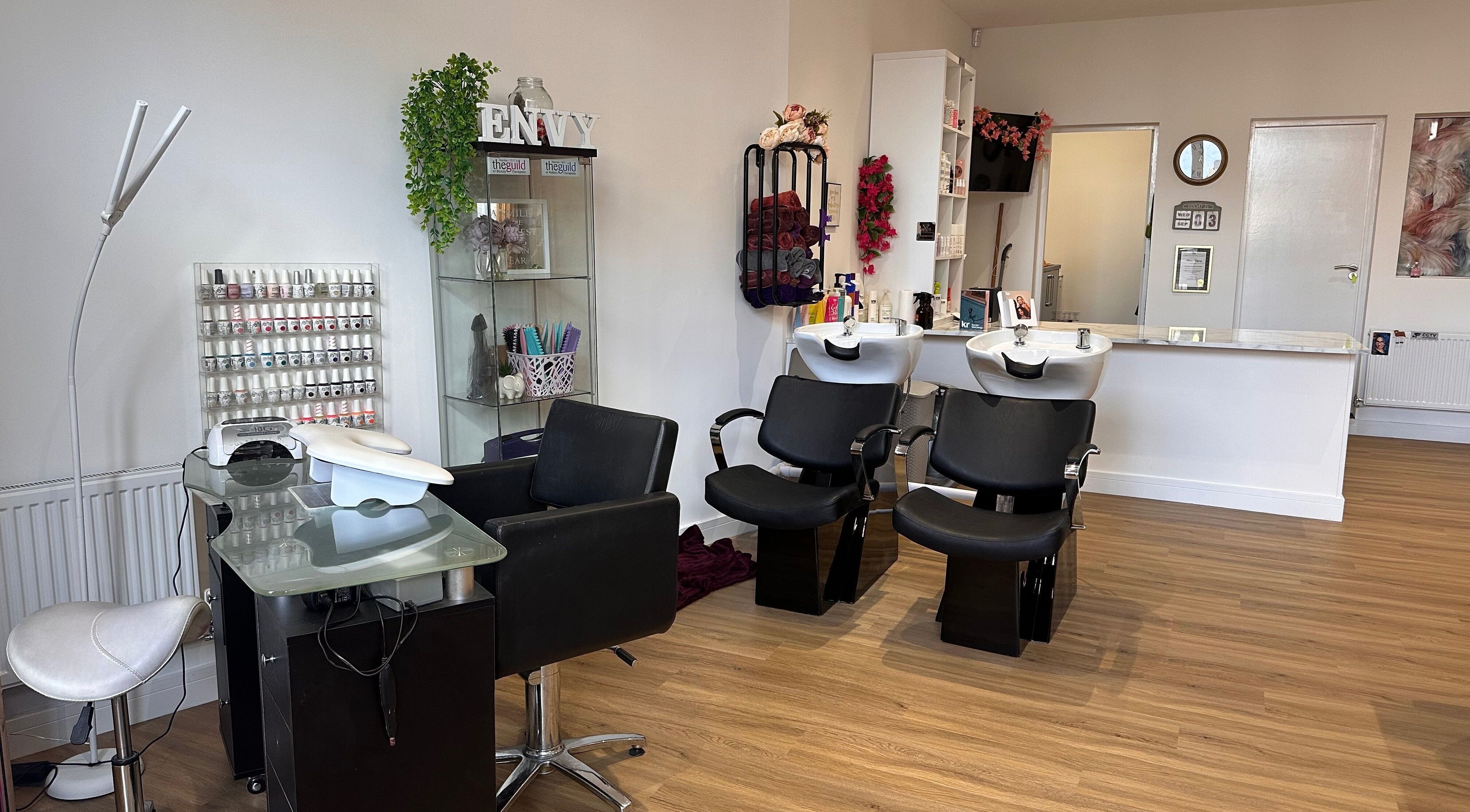 Modern interior of Envy Salon in Redcar, TS10 1AD, England, showcasing stylish black chairs and beauty stations.