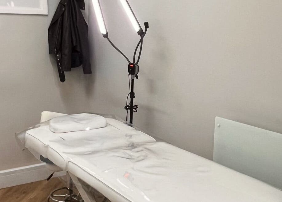 COSMO beauty room in Bletchley, England, GB, featuring a white treatment bed and bright lighting.