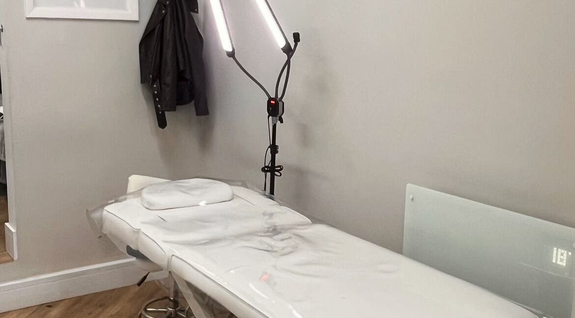 COSMO beauty room in Bletchley, England, GB, featuring a white treatment bed and bright lighting.