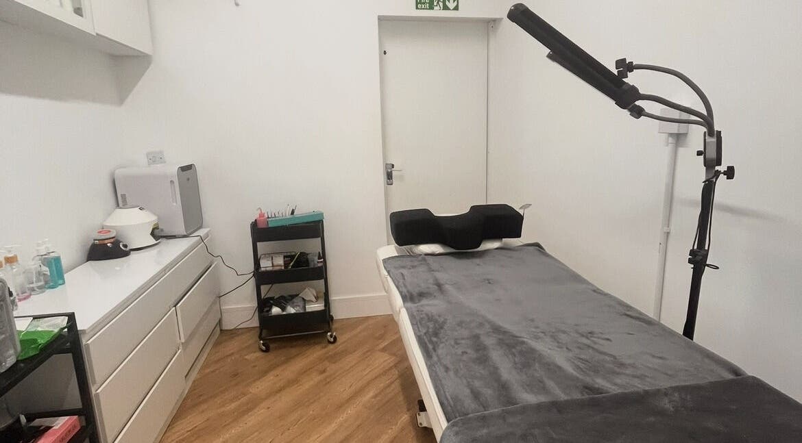 Cozy treatment room at COSMO in Bletchley, England, GB, featuring a massage table and modern equipment.