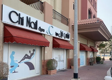 Front view of Chi Nail Spa - JVT, located in Dubai, Dubai, AE with red awnings and spa signage.