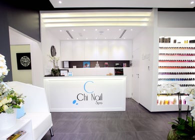 Reception area of Chi Nail Spa - JVT, showcasing modern decor and vibrant nail colors in Dubai, Dubai, AE.