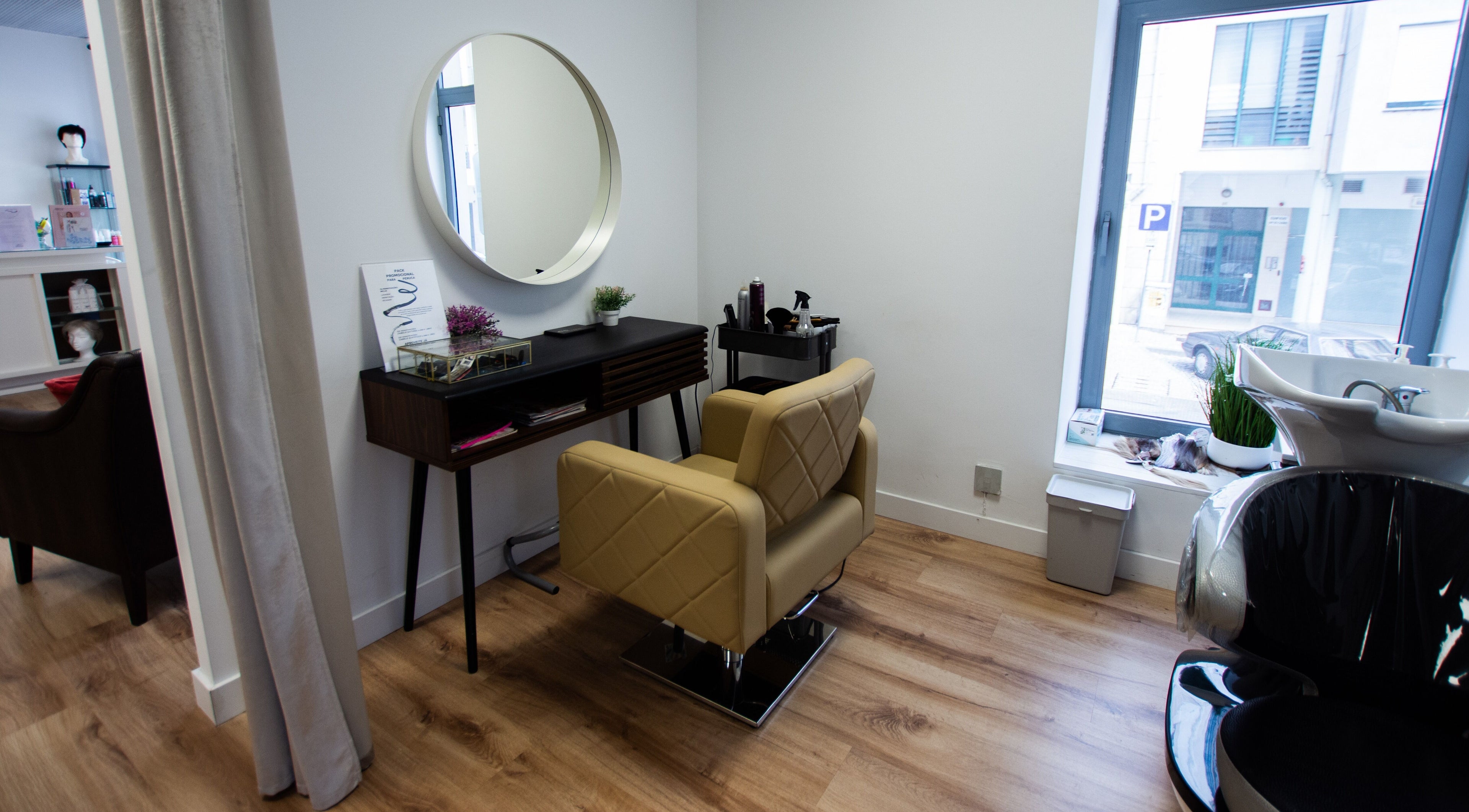 Espaço moderno de Tiago Teixeira Soluções Capilares em Coimbra, Coimbra, PT, com poltrona e espelho elegante.