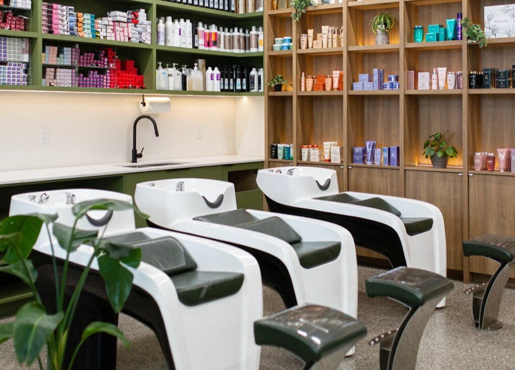 Elegant hair washing stations at Initial Salon, Richmond, British Columbia, CA with products neatly displayed.
