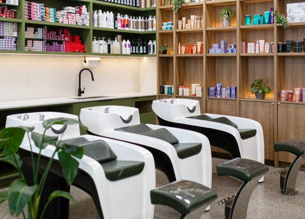 Elegant hair washing stations at Initial Salon, Richmond, British Columbia, CA with products neatly displayed.