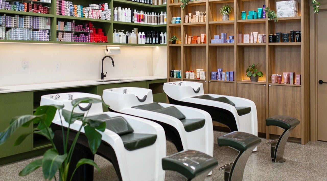Elegant hair washing stations at Initial Salon, Richmond, British Columbia, CA with products neatly displayed.