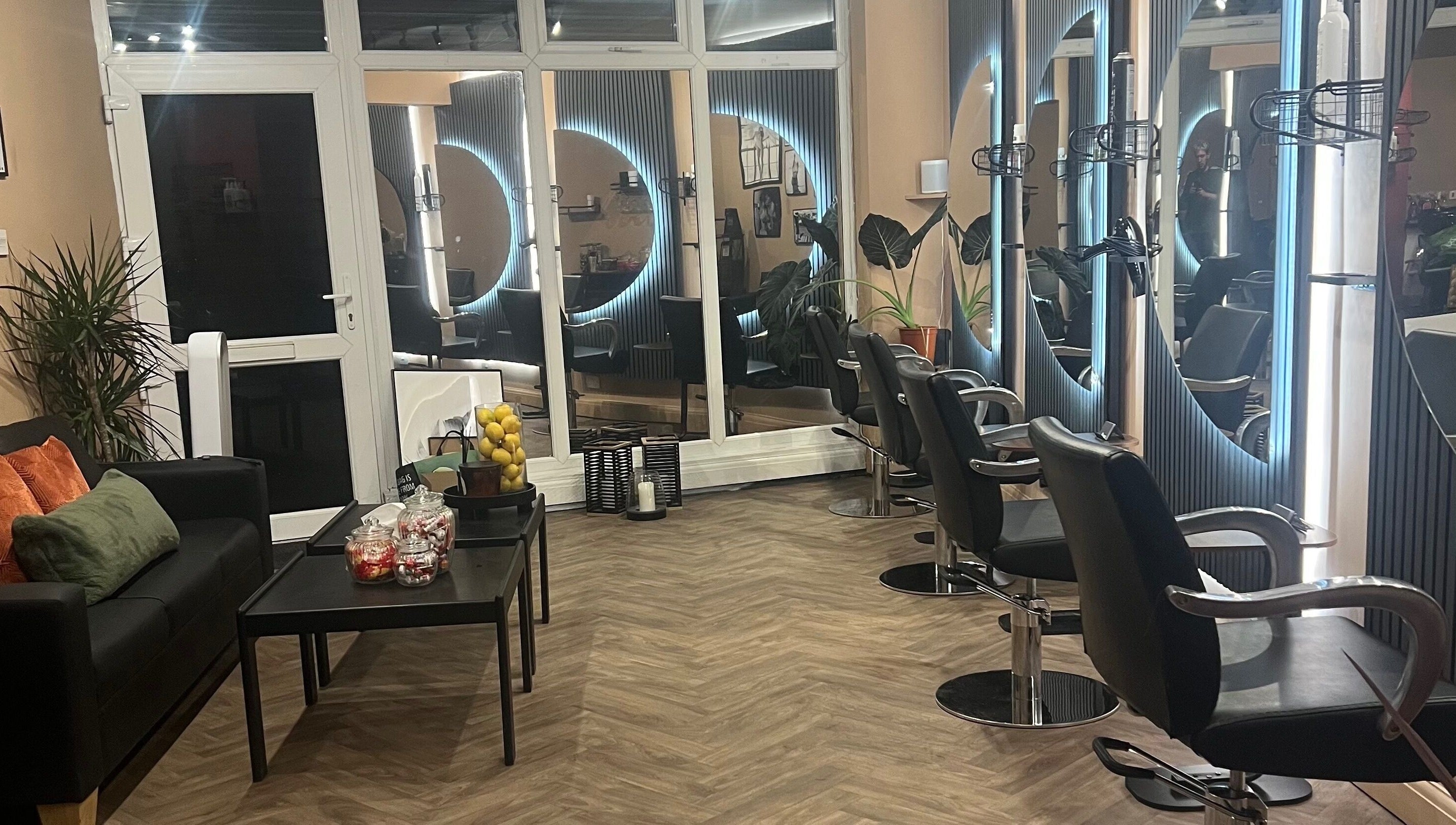 Modern salon at Haar, Kidderminster, England, GB with stylish chairs and illuminated mirrors.