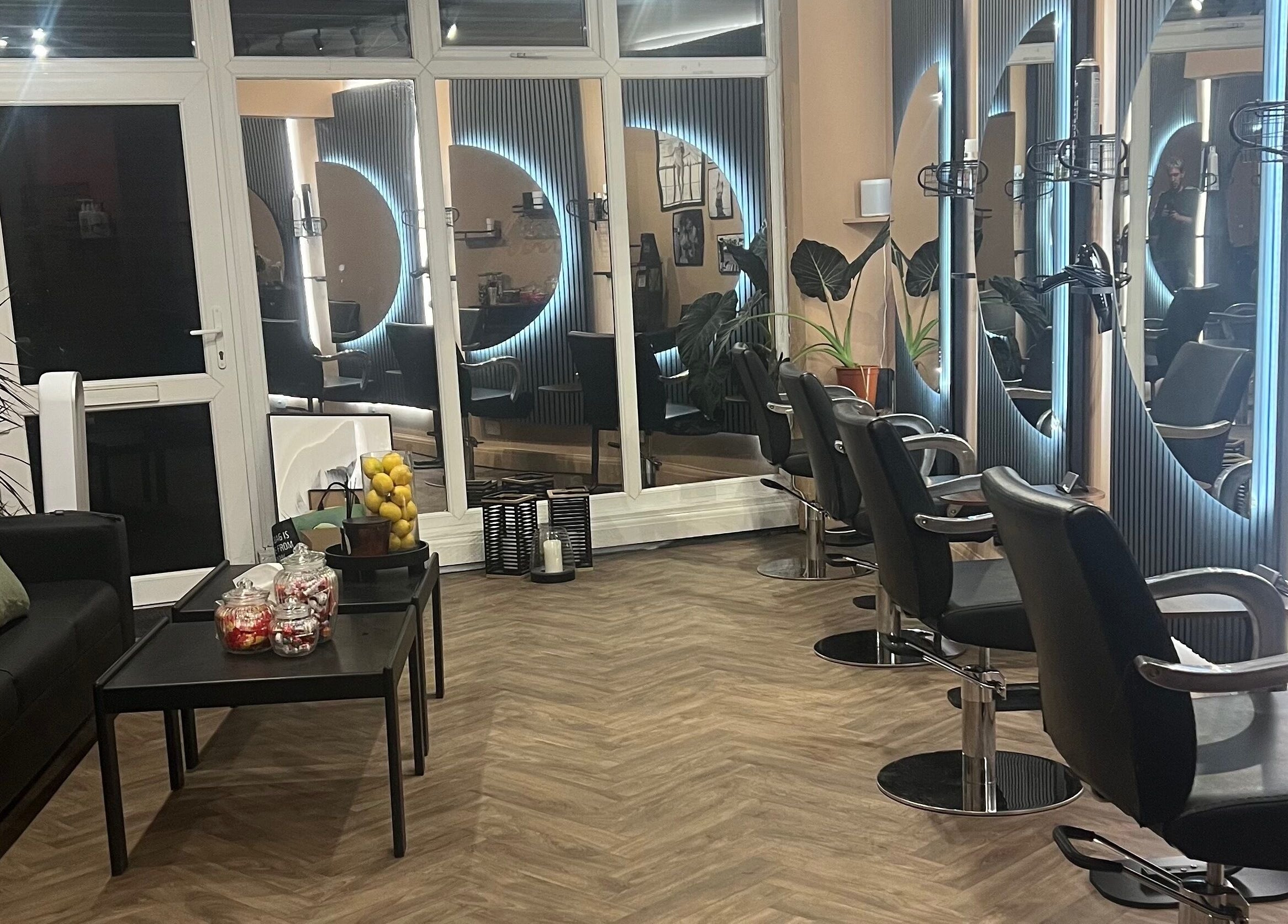 Modern salon at Haar, Kidderminster, England, GB with stylish chairs and illuminated mirrors.