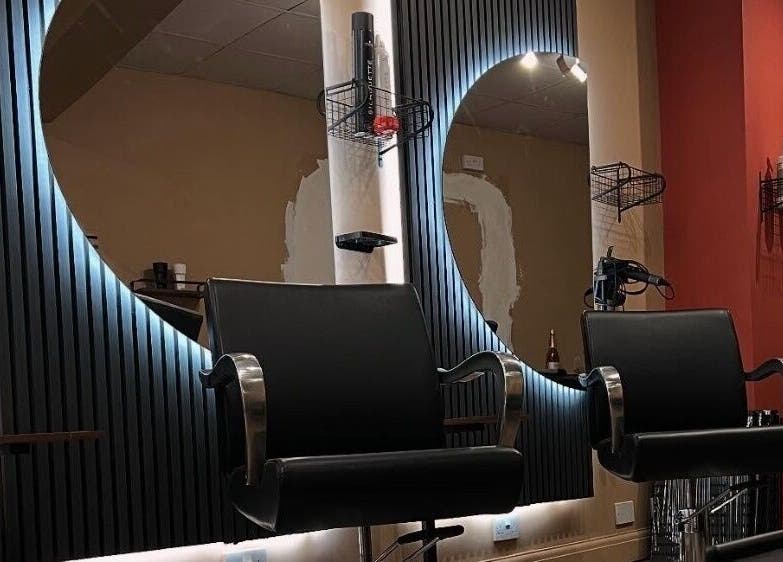 Modern salon interior at Haar, Kidderminster, England, GB, featuring stylish chairs and illuminated mirrors.