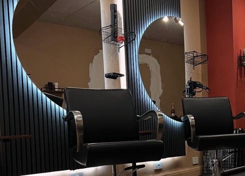 Modern salon interior at Haar, Kidderminster, England, GB, featuring stylish chairs and illuminated mirrors.