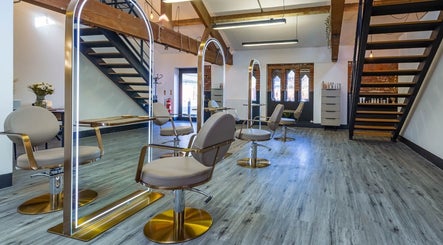 Modern salon chairs at Ellie Holmes Creative Hair, Preston, England, GB, featuring stylish wooden beams and mirrors.