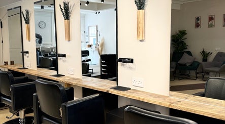 Modern salon interior at Niki Bartos Hairstylist, Norwich, England, GB with elegant mirrors and seating.
