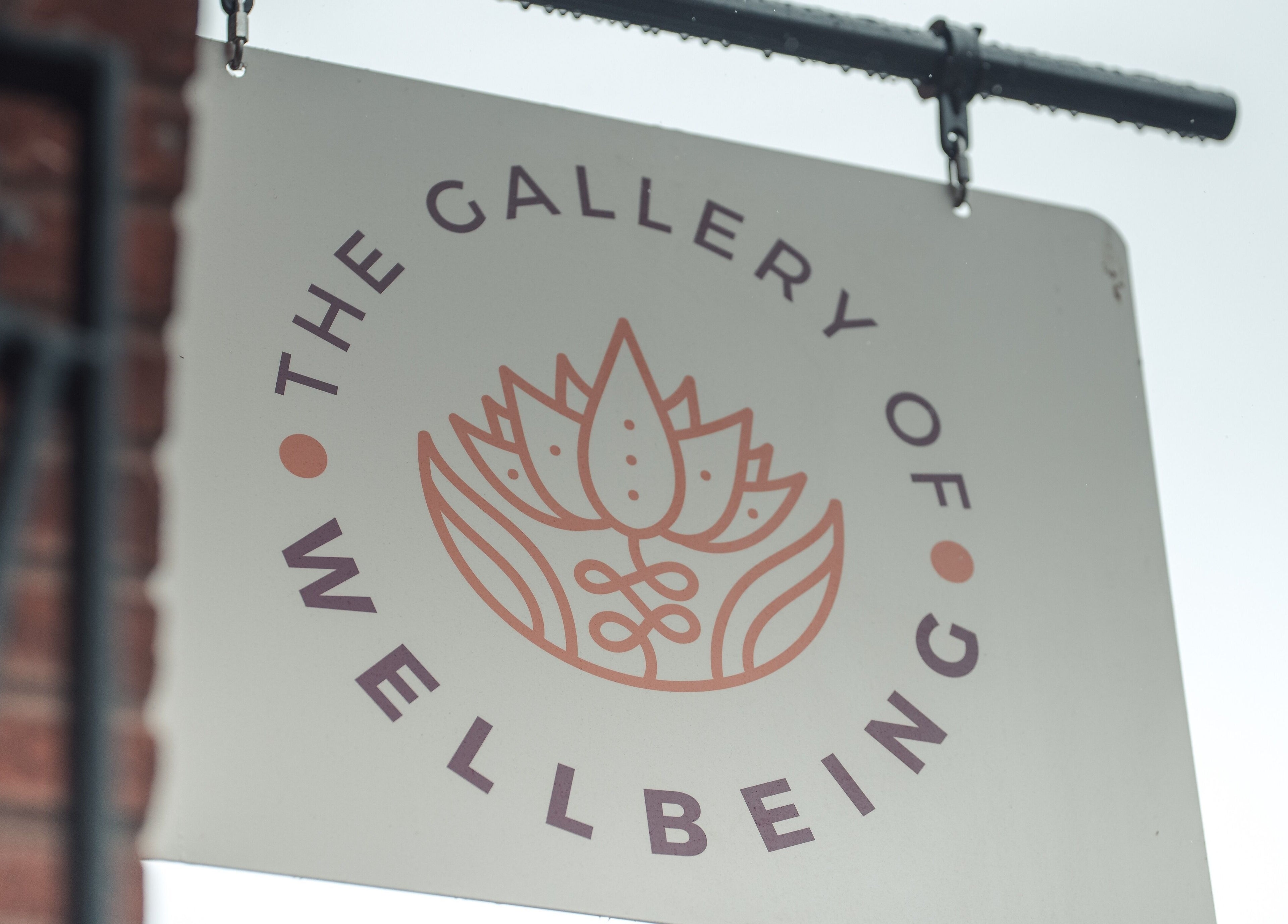Logo sign of Gallery of Wellbeing, Hereford, England, GB with a lotus flower design.