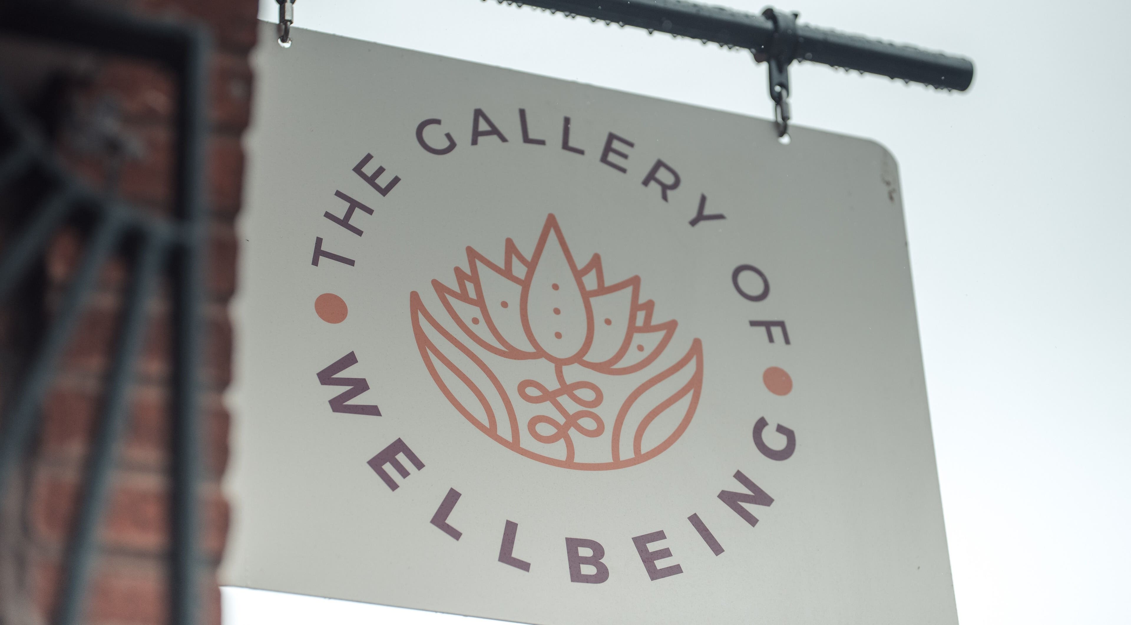 Logo sign of Gallery of Wellbeing, Hereford, England, GB with a lotus flower design.