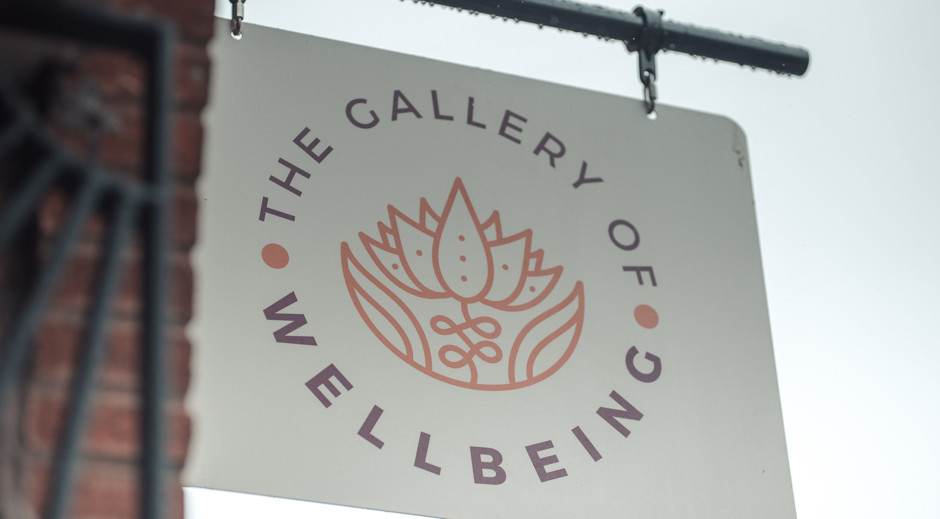 Logo sign of Gallery of Wellbeing, Hereford, England, GB with a lotus flower design.