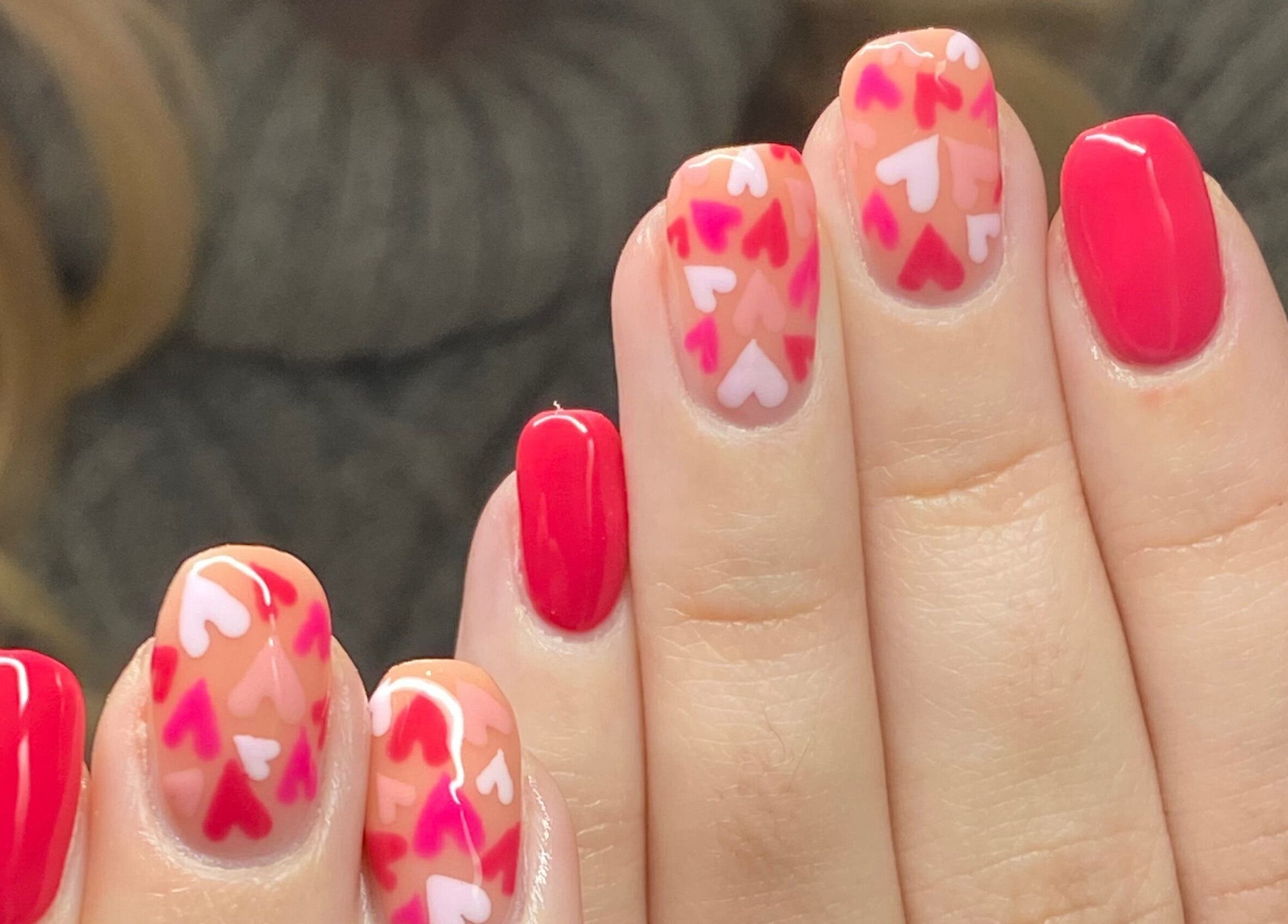 Vibrant heart nail art at Bealer Beauty in Basingstoke, England, GB. Showcases red and pink designs.
