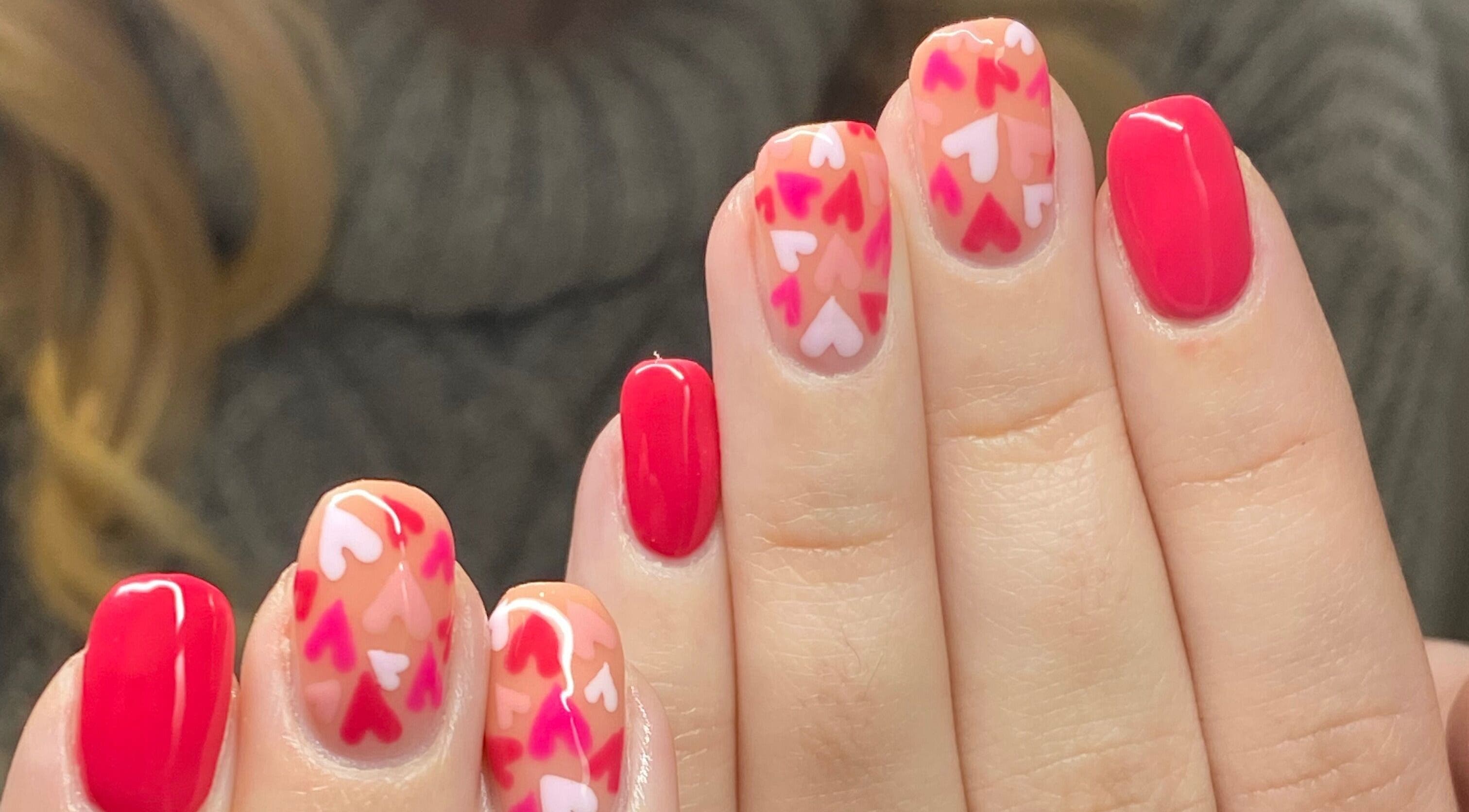 Vibrant heart nail art at Bealer Beauty in Basingstoke, England, GB. Showcases red and pink designs.