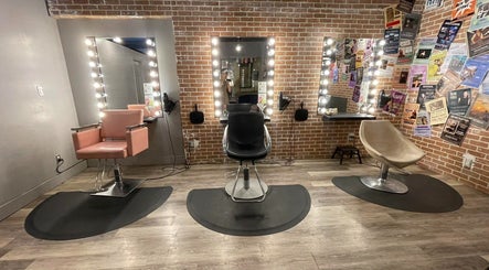 Trendy styling chairs at BEATNIK Salon, Banff, Alberta, CA with illuminated mirrors and brick wall backdrop.