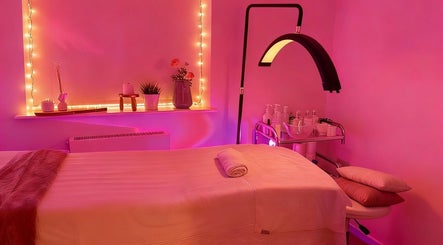 Relaxing spa room at Club Love Yourself, London, England, GB with gentle pink lighting and cozy massage setup.