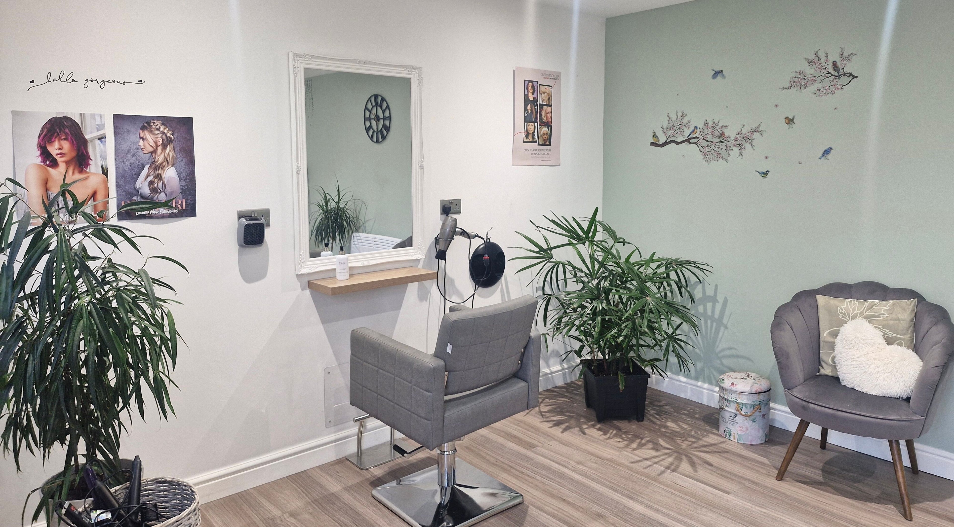 Relaxing styling area at SamBrayHair, Thurmaston, England, GB with mirror, plants, and cozy seating.