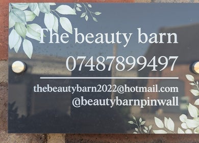 The Beauty Barn at Pinwall sign in Atherstone, England, GB with contact details and decorative leaves.