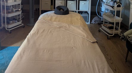 Serene massage room at The Beauty Barn at Pinwall, Atherstone, England, GB, with a cozy massage bed setup.