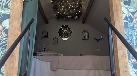 Cozy treatment room at The Beauty Barn at Pinwall in Atherstone, England, GB, featuring warm lighting and elegant decor.