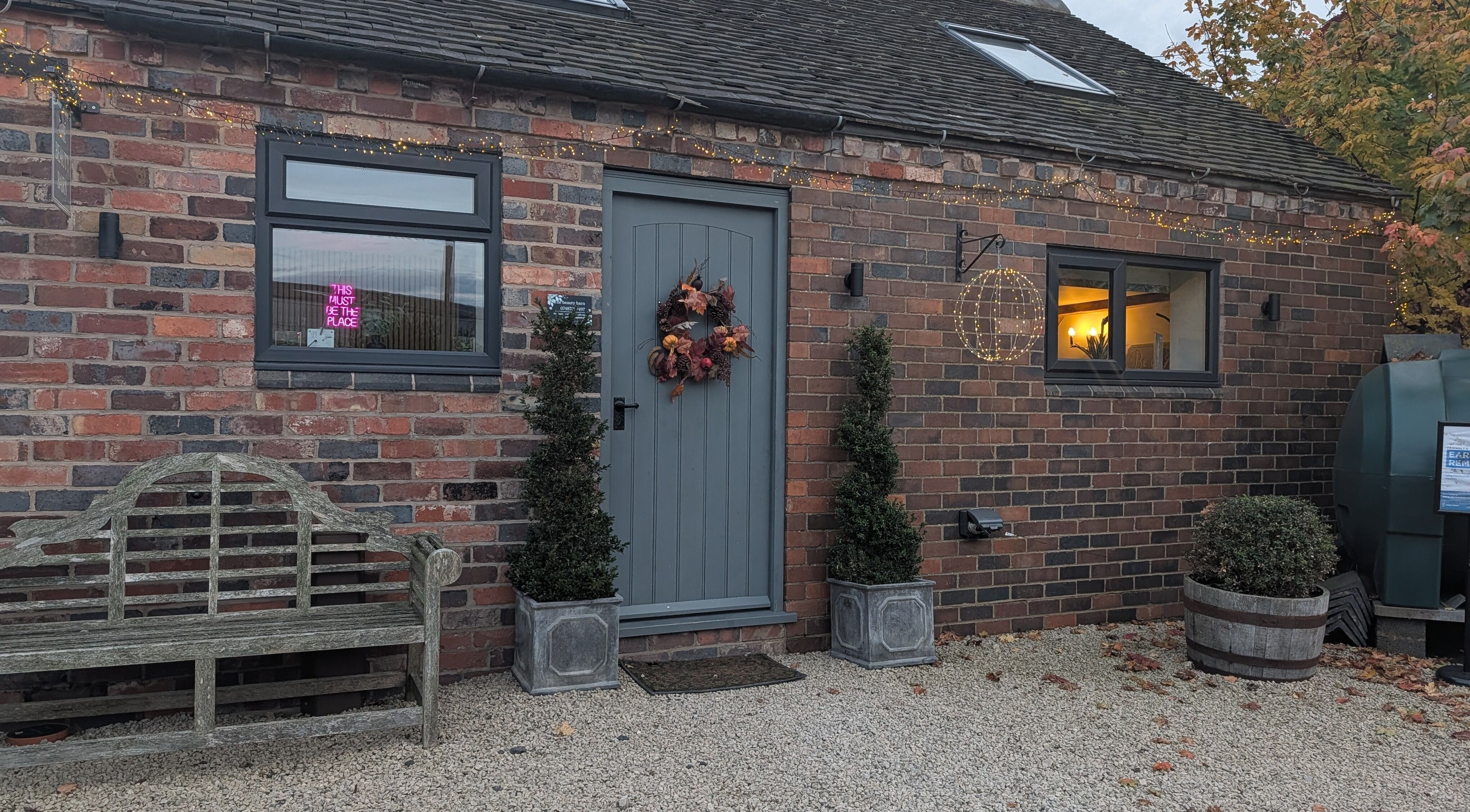 Charming brick exterior of The Beauty Barn at Pinwall in Atherstone, England, GB adorned with lights.