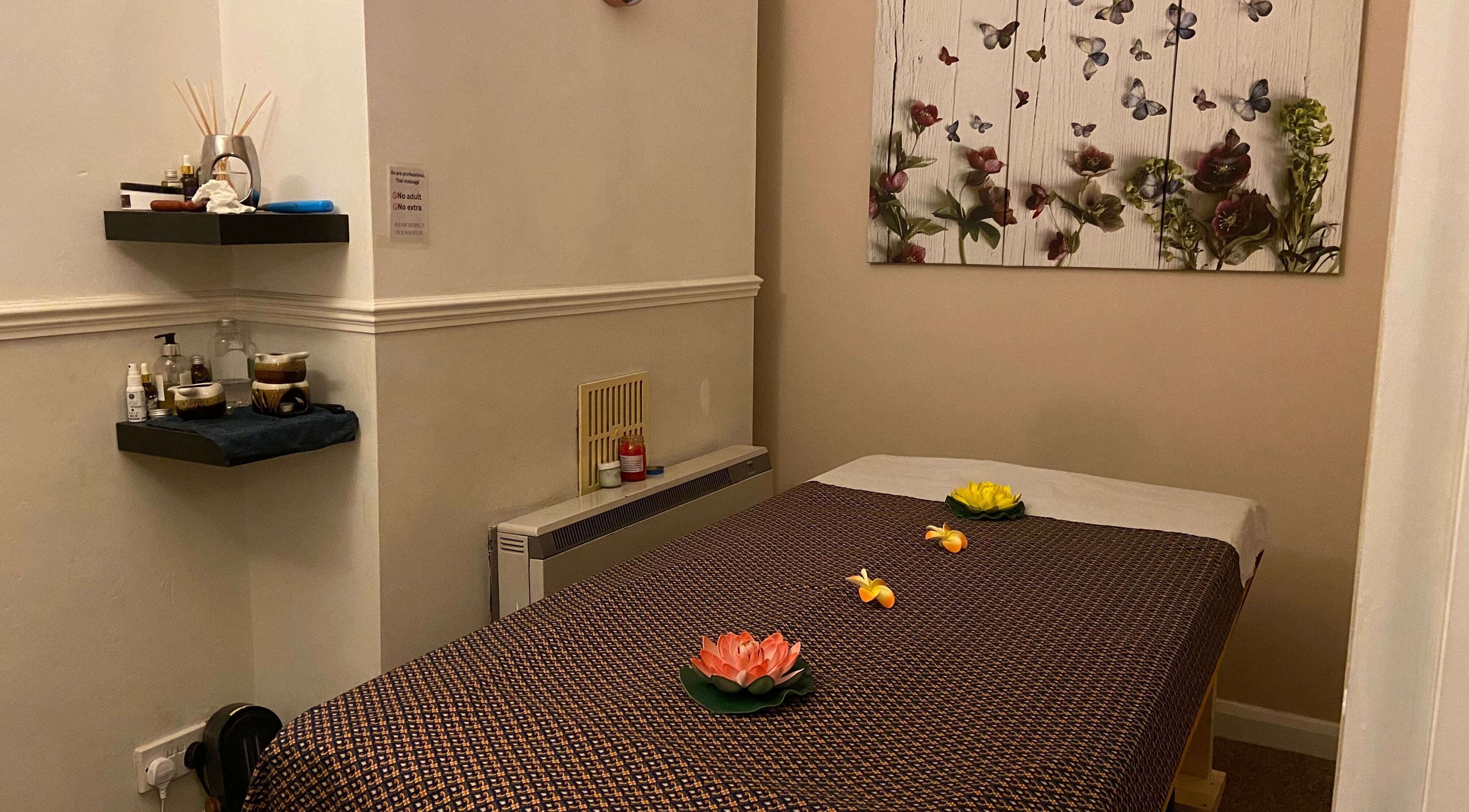 Relaxing massage room at Ramphai Thai Massage Therapy, Bristol, England, GB, featuring decorative art and flowers.