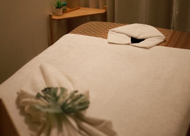 Massage table at Thanwa Thai Massage, Melbourne, Victoria, AU, with soft white towels and serene decor.