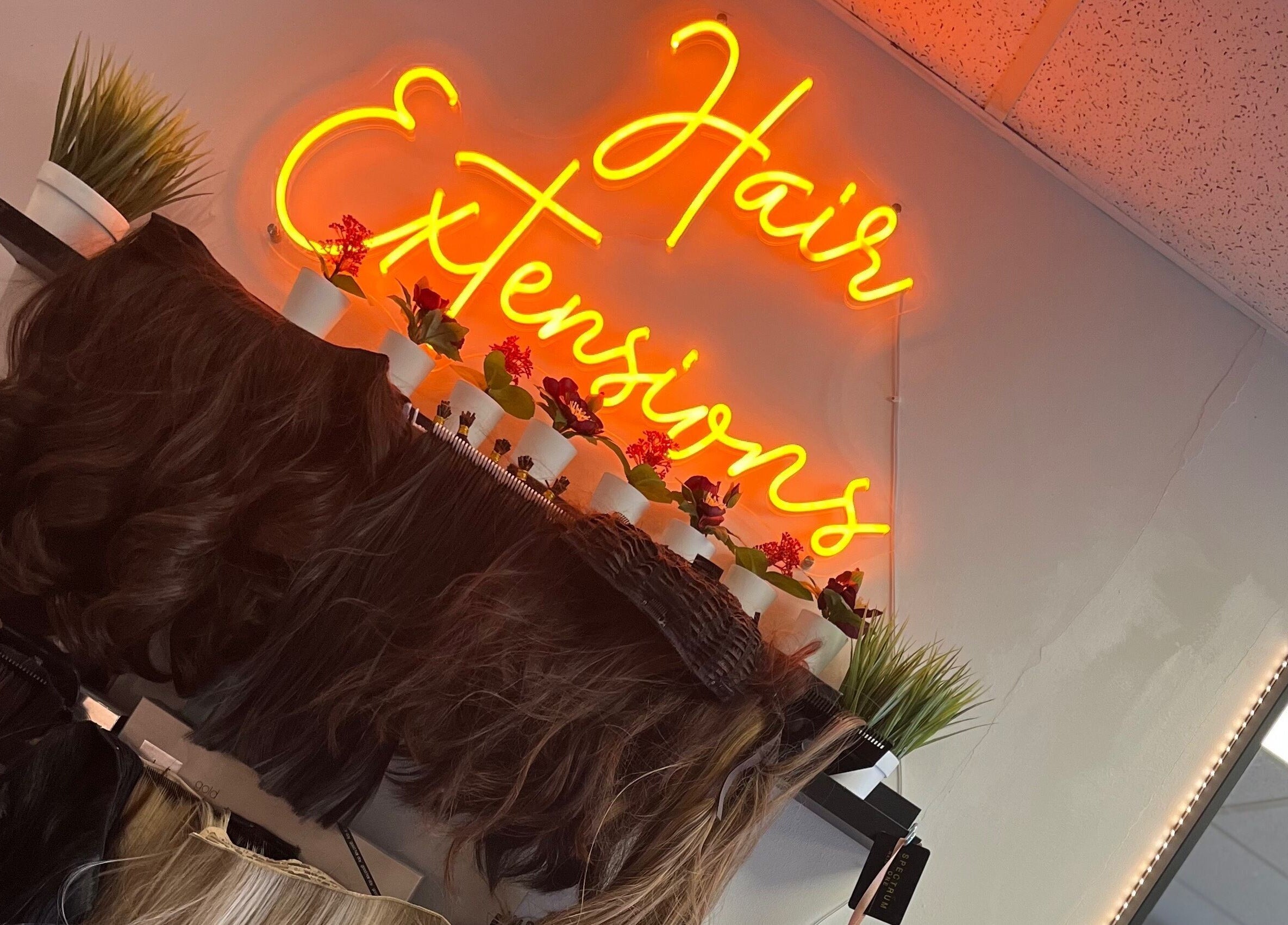 Hair extensions display under glowing neon sign at Gorgeous, Wolverhampton, England, GB.