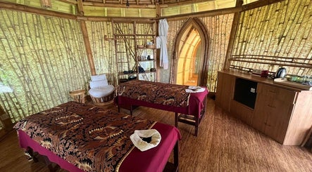 Relaxing massage room at Green Village Spa in Bali, Bali, ID, showcasing bamboo walls and cozy decor.