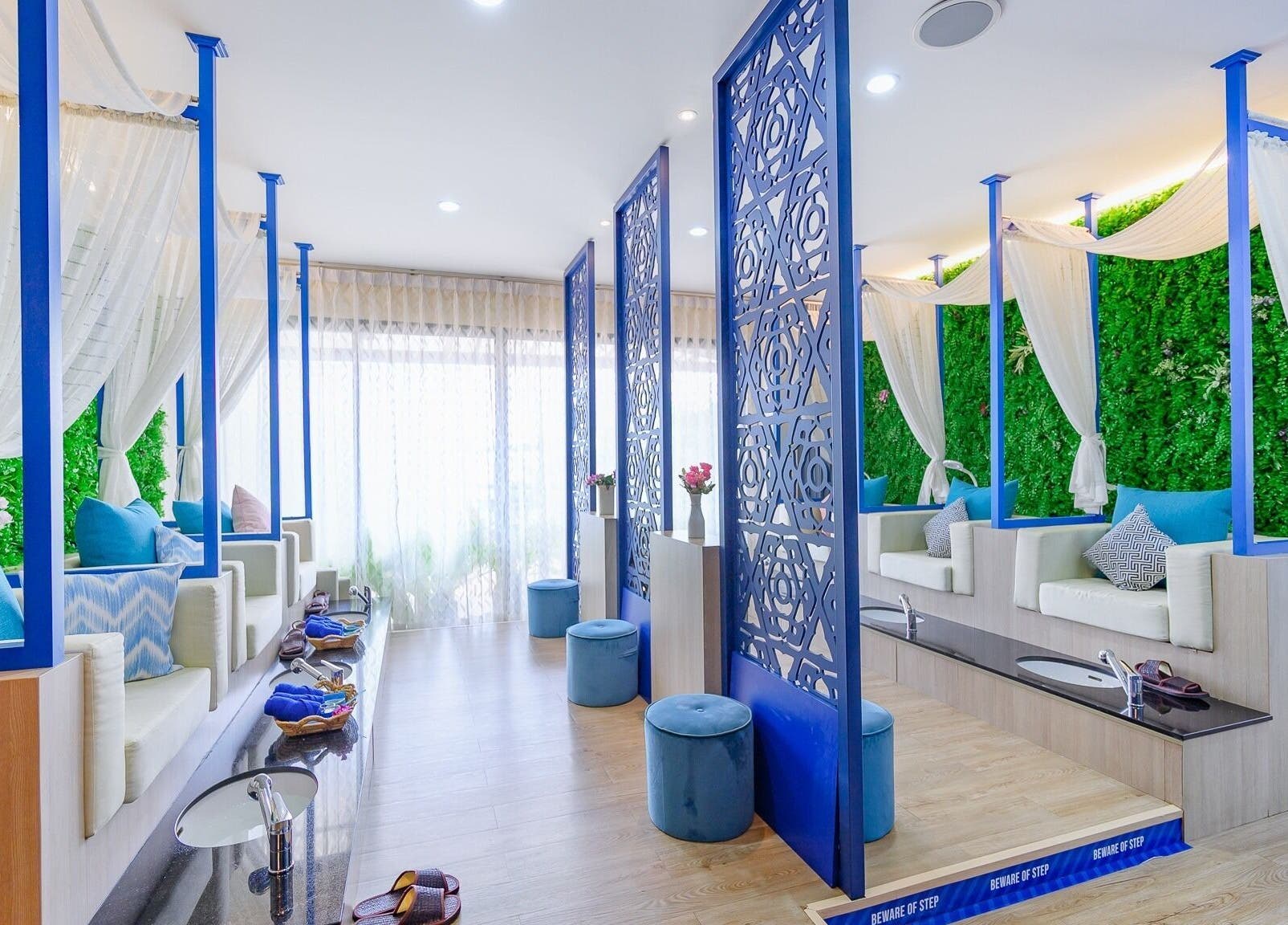 Elegant seating area at Apsara Spa, Tambon Choeng Thale, Phuket, TH, with lush greenery and blue accents.