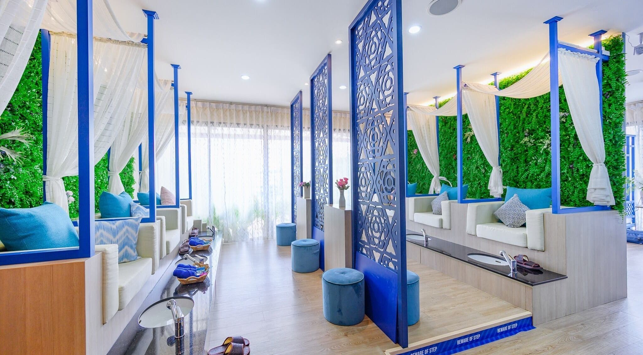 Elegant seating area at Apsara Spa, Tambon Choeng Thale, Phuket, TH, with lush greenery and blue accents.